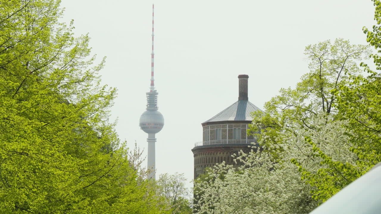 la torre de televisión de berlín se alza en la distancia, bajo el lienzo de un cielo azul