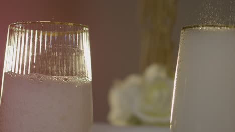 close up of person pouring champagne into glasses at table set for meal at wedding reception