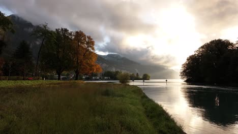 a peaceful and tranquil scene of lake walensee, switzerland, enveloped in autumn mist and clouds. the calm waters and scenic surroundings create a serene atmosphere.