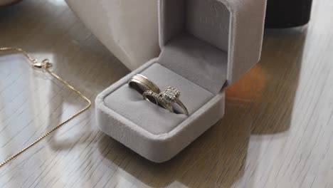 box with three wedding rings made of white gold on a wooden table