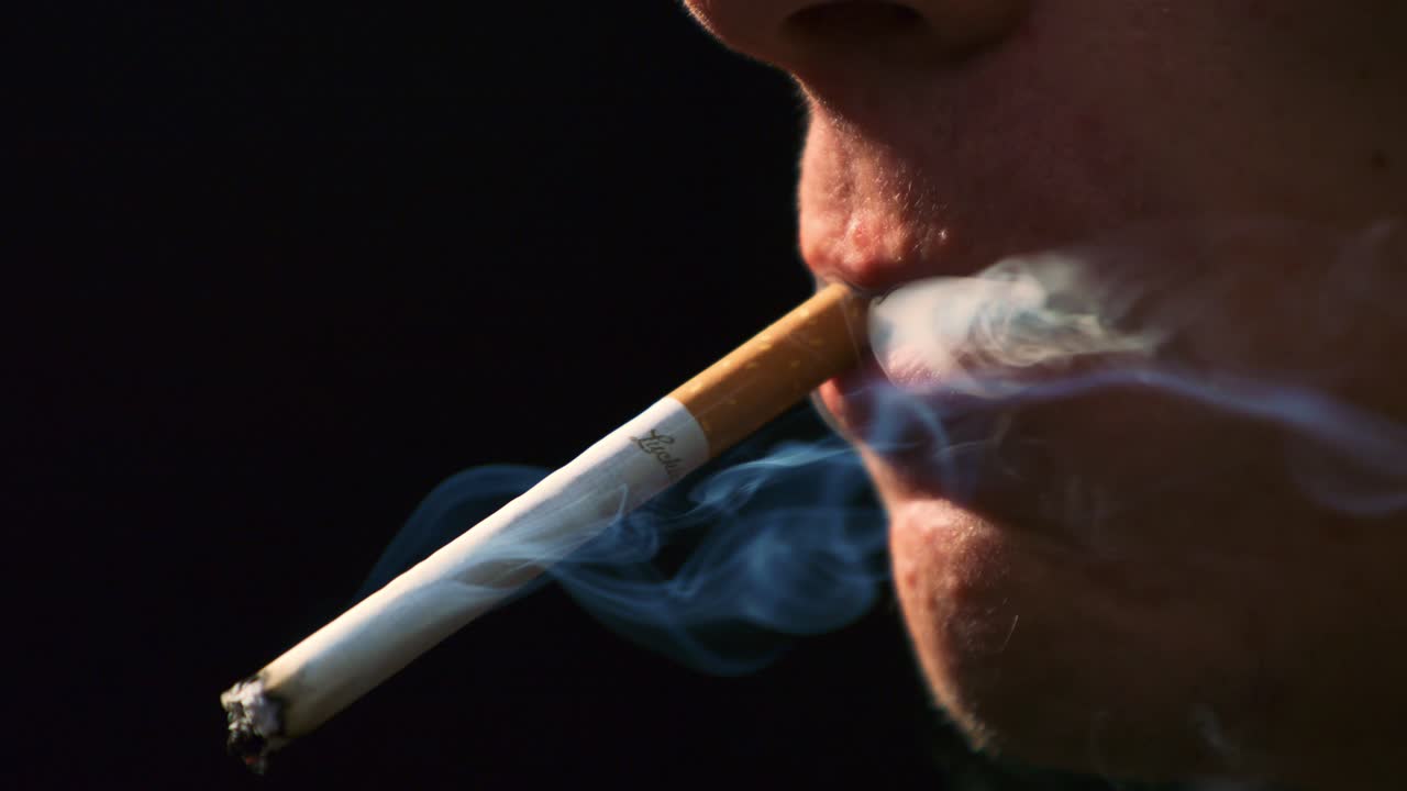 hombre encendiendo y fumando un cigarrillo en súper cámara lenta
