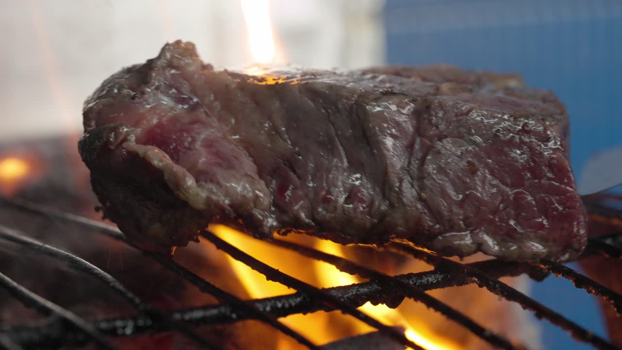 un cocinero convierte un filete raro en una barbacoa con brasas y llamas
