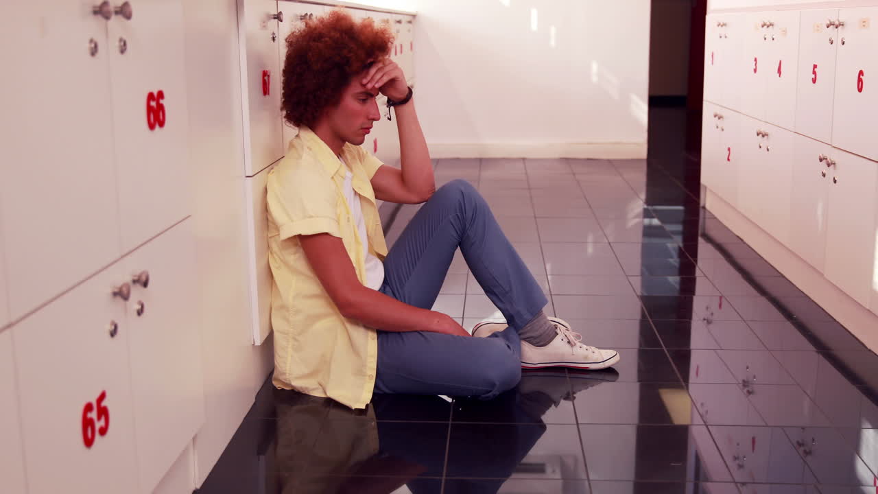 Depressed student sitting on the floor 
