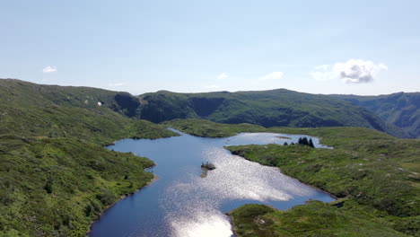 drone gliding over a crystal-clear lake on vidden plateau with panoramic mountain views above bergen