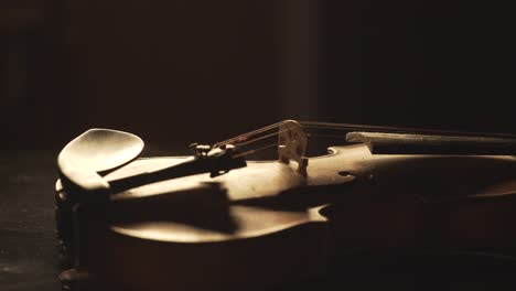 close up of old violin, dramatic light changes over the instrument , classical symphony music video footage