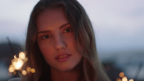 close-up-sparklers-portrait-of-attractive-caucasian-woman-celebrating-new-years-eve-enjoying-independence-day-celebration-on-beach-at-sunset