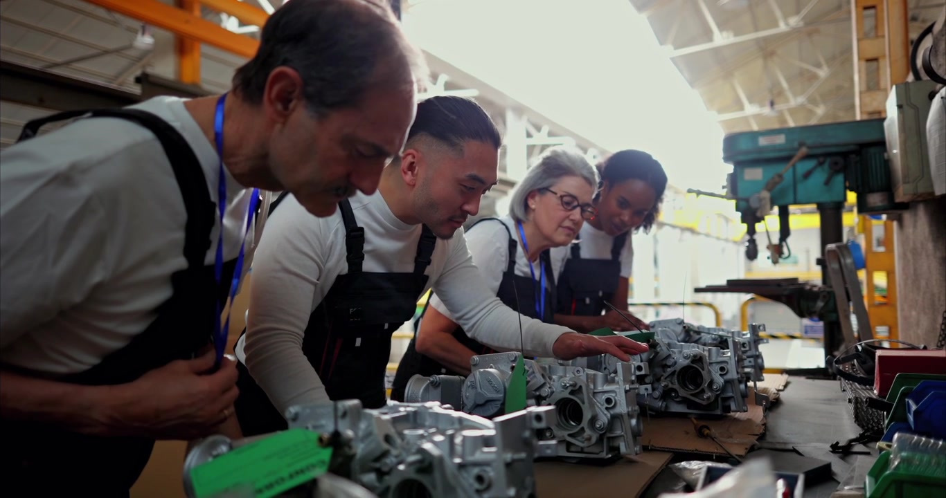 Diverse Team of Engineers Inspecting Mechanical Parts in Factory