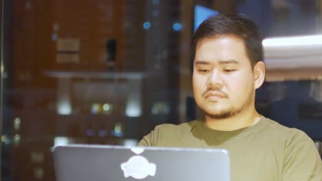 Hombre-Asiático-Mientras-Trabaja-En-Una-Computadora-Portátil-En-El-Turno-De-Noche