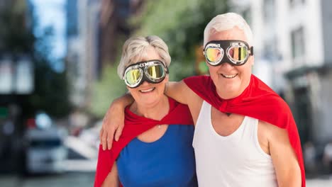 animation of happy senior caucasian couple with superhero costumes over city