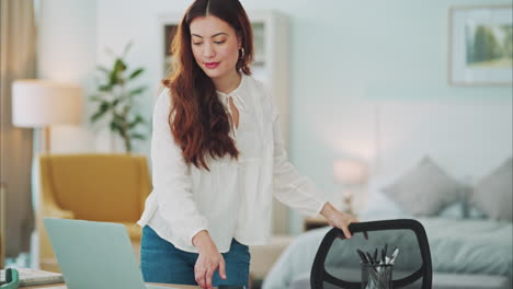 woman, laptop and typing at desk in home