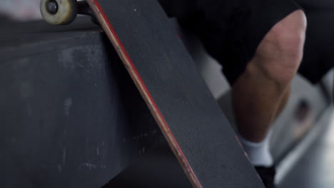 Young-hipster-resting-with-skate-board-at-skate-park.-Closeup-skateboard.