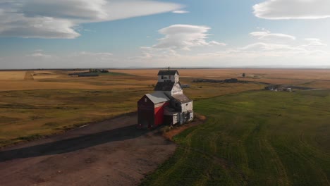 Aerial-drone-shot-of-Old-historical-Alberta-Grain-Elevator-surrounded-by-agricultural-fields-on-all-sides-the-town-of-Raley,-southern-Alberta,-Canada