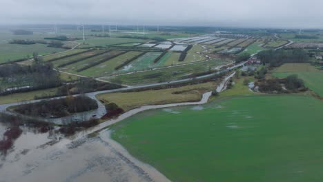 Vista-Aérea-De-La-Crecida-Del-Agua-En-Primavera,-Inundación-Del-Río-Alande,-Agua-Marrón-Y-Fangosa,-Campos-Agrícolas-Bajo-El-Agua,-Día-Nublado,-Amplio-Disparo-De-Drones-Avanzando