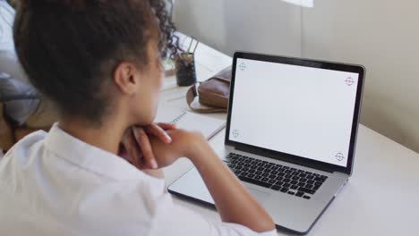 mujer de negocios afroamericana usando una computadora portátil con espacio de copia en la oficina creativa