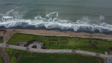 early morning video of a park in lima, peru called "bosque del bicentenario" drone flies back while tilting camera gimbal upwards, showing the pacific ocean shore waves