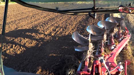 tractor pulling reversible plough on the field, cultivating soil for season