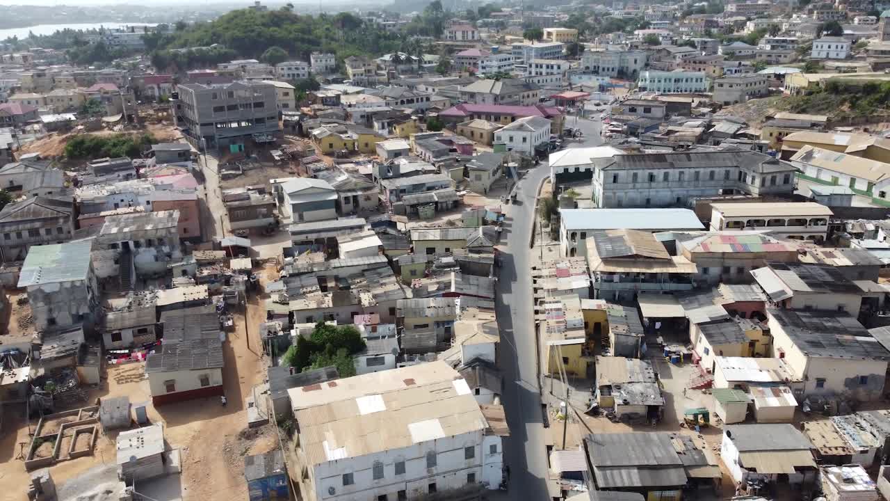 Vista aerea soleggiata di Cape Coast, Ghana, che mostra una spiaggia dorata, onde oceaniche e acqua cristallina lungo la costa atlantica, catturando la vivace atmosfera costiera dell'Africa