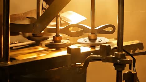 metalworking machines press heated metal pieces in an industrial factory, creating sparks as pressure is applied. the process showcases the intensity of manufacturing and engineering