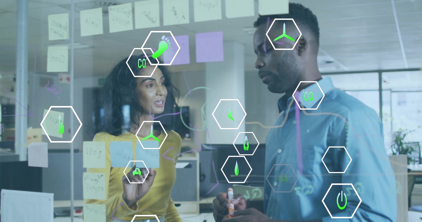 Animation of icon in hexagons over diverse coworkers discussing reports on transparent board