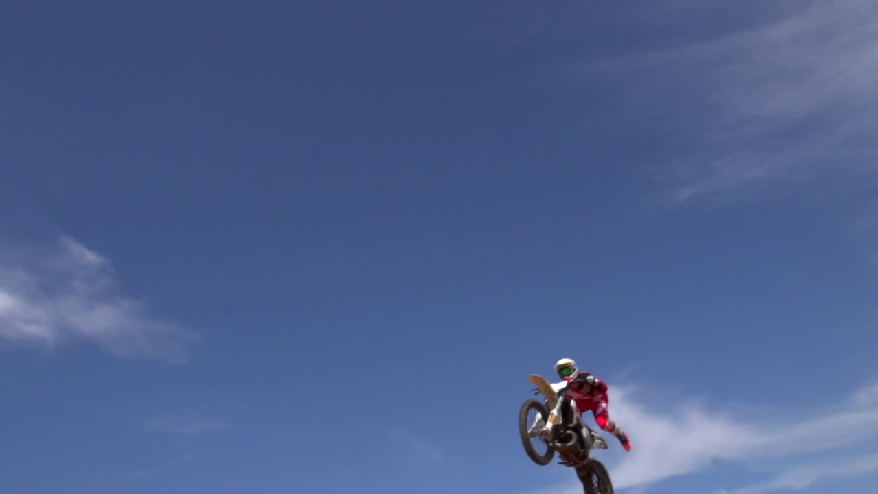 모토크로스 라이더가 더트 점프에서 카메라 위로 날아 큰 공기를 잡습니다.