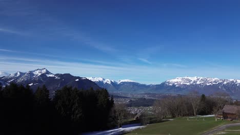 Drone-fly-above-mountain-hut-with-amazing-view-revealing-winter-mountain-landscape-with-snow-capped-mountains-on-a-sunny-day-in-Austria