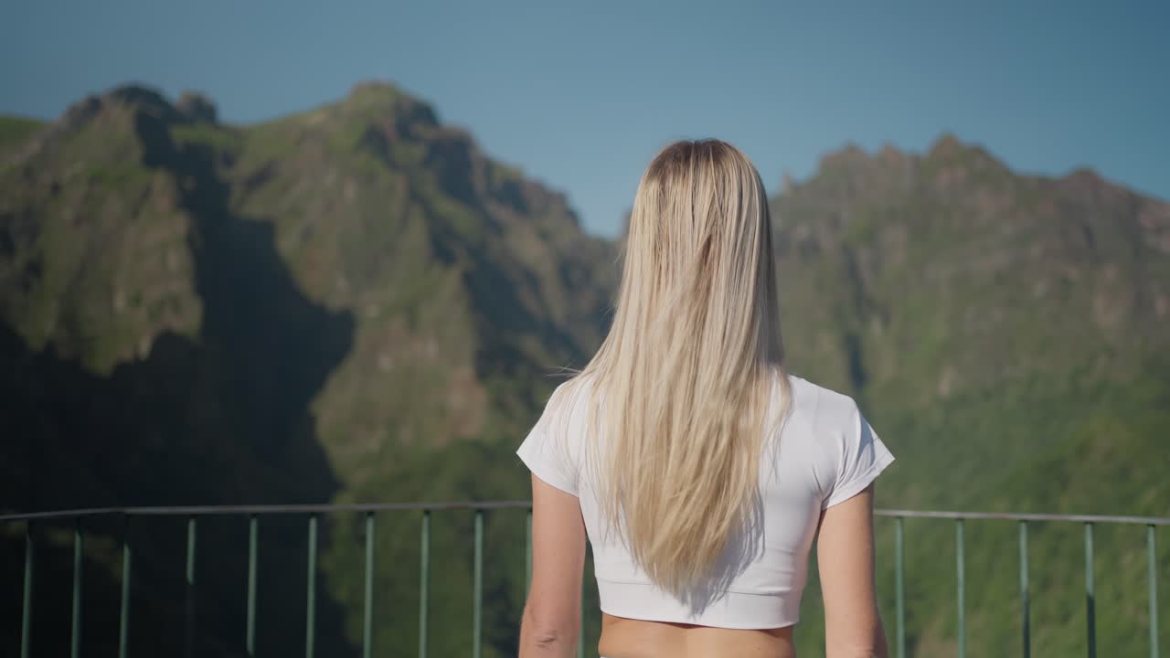 산의 전망대에서 강철 레일링을 향해  ⁇ 는  ⁇ 은 여인