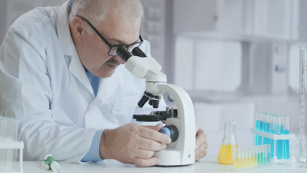 laboratorio de microbiología: científico trabaja con varias bacterias. concepto de investigación farmacéutica para antibióticos curando enfermedades con medicamentos que mejoran el adn. un hombre médico con un microscopio. imágenes de alta calidad 4k