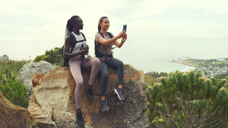 two hikers using phone to pose