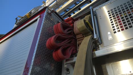 fire hoses on a shiny fire engine at sunrise outside of a fire station