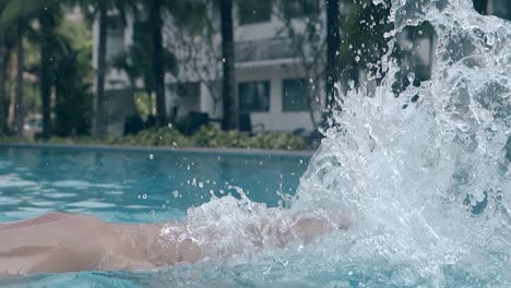 mujer con piernas rectas salpica agua de la piscina en cámara lenta