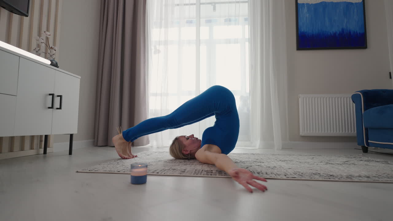 una mujer en casa hace ejercicios sin salir de casa. entrenamiento en el hogar. una mujer se entrena en la alfombra con un traje azul