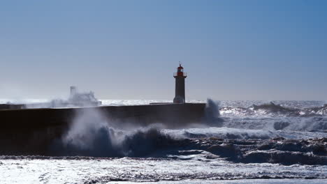 des vagues orageuses se heurtent au phare de porto, au portugal