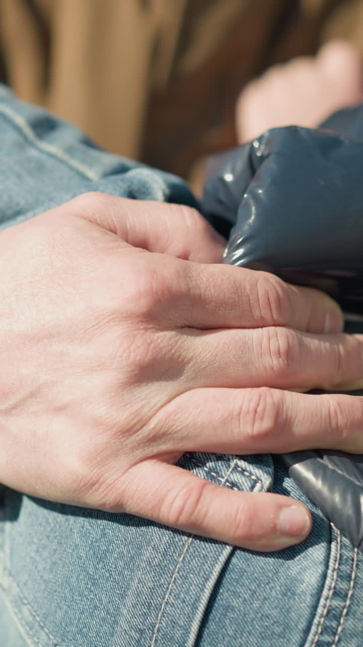 un primer plano de un adulto llevando a un niño pequeño que está durmiendo, con la mano del adulto sosteniendo firmemente al niño, con un fondo borroso