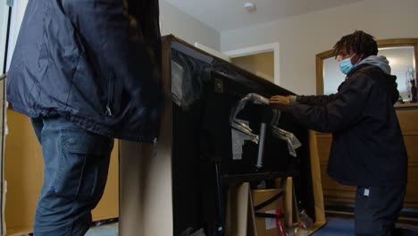 two men assembling furniture in a bedroom