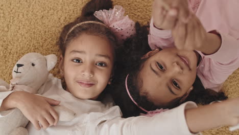 girls waving wands on floor smiling