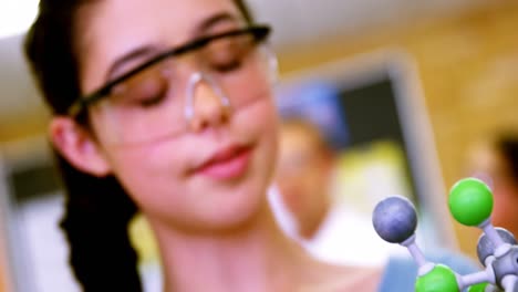 Close-up-of-schoolgirl-examining-molecule-model-4k