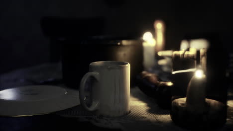 soft candlelight illuminates a cup and objects on a table at night