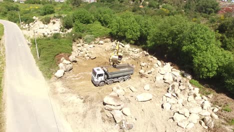 excavator removing sand into dump truck