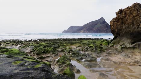 Paisaje-Cinematográfico-Natural-Del-Océano-Con-Rocas-Erosionadas-Llenas-De-Musgo-Verde,-Charcos-De-Agua-De-Mar-Y-Olas