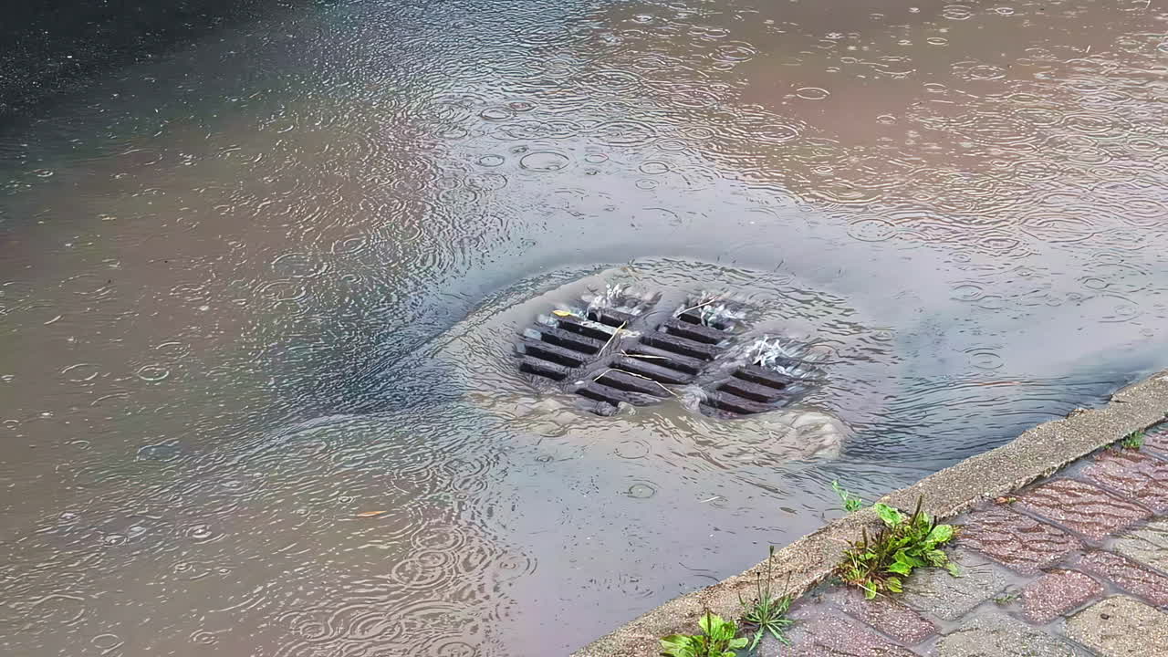 Water flows into a drain during heavy rain in Jelgava, Latvia