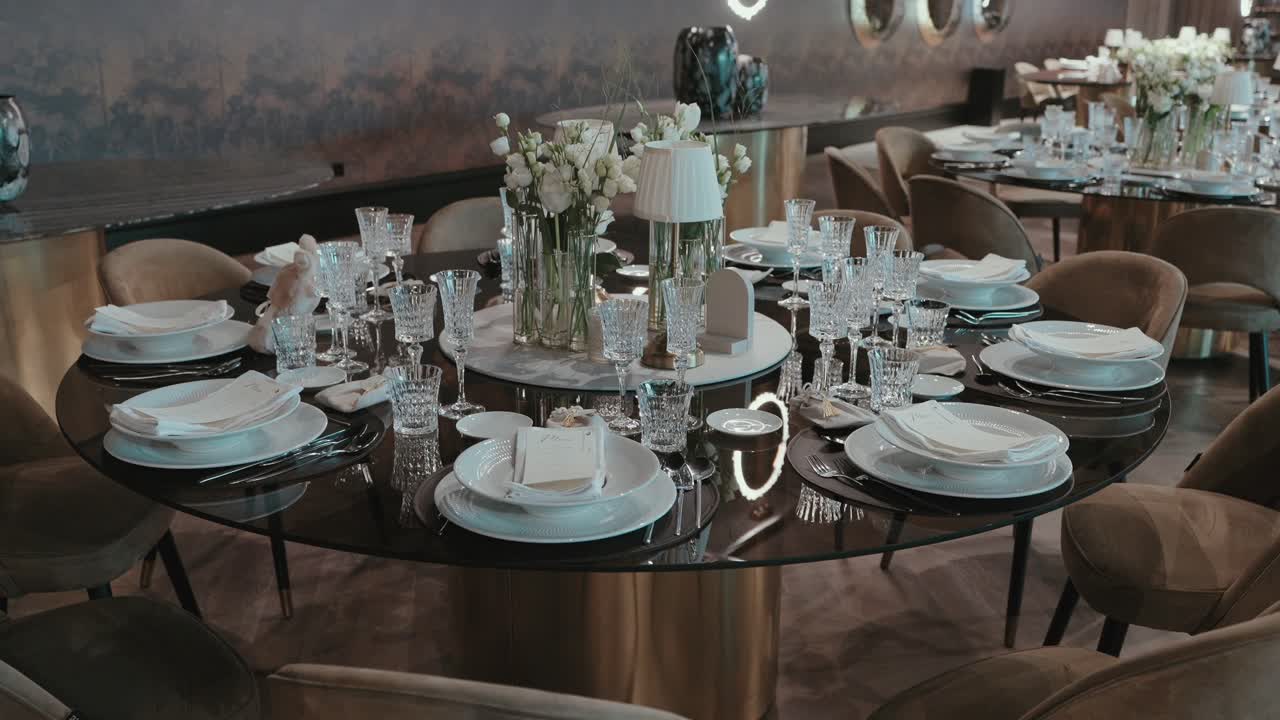 Luxury banquet table set with crystal glasses white florals and elegant gold base chairs