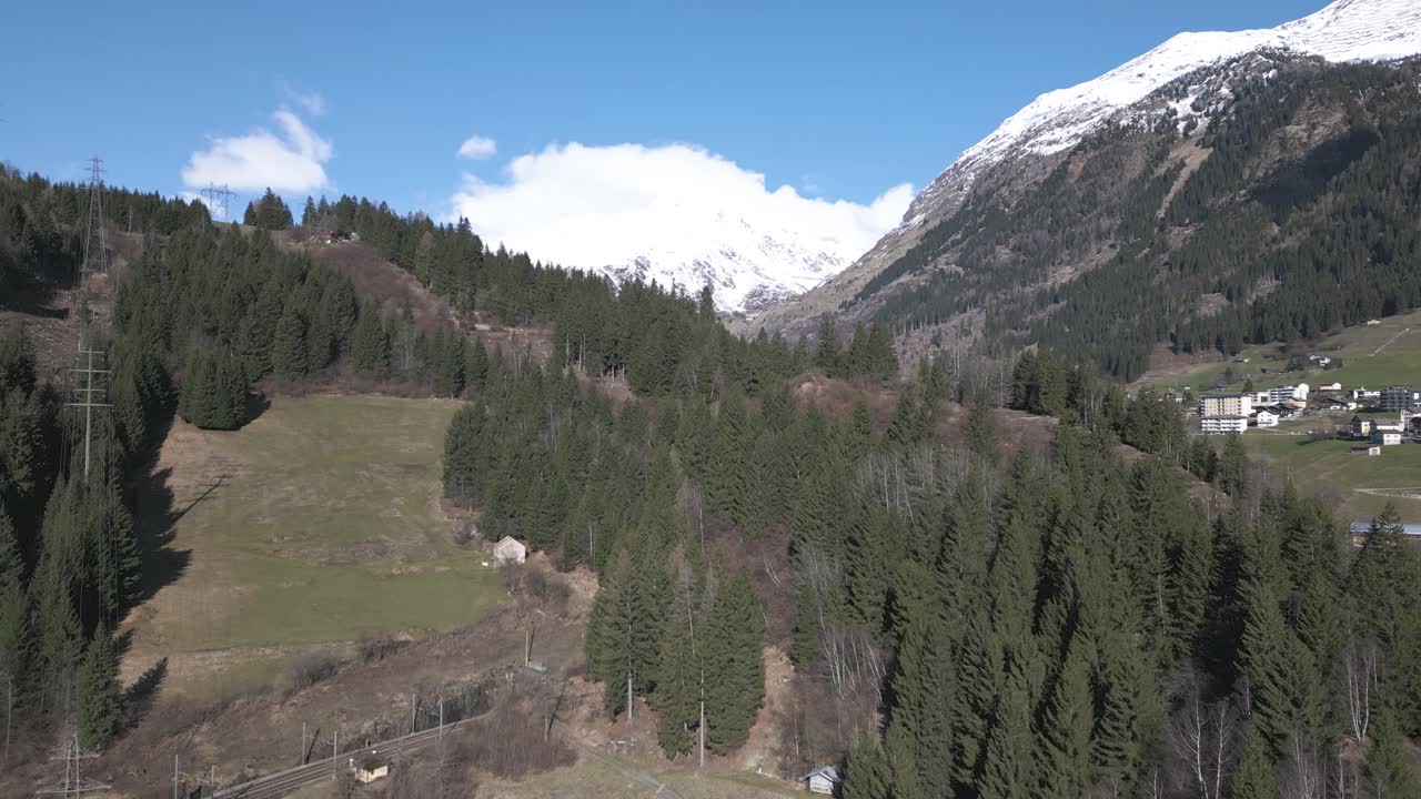 vista aérea de un soleado día de primavera en los alpes suizos, paisaje y aldea bajo picos cubiertos de nieve