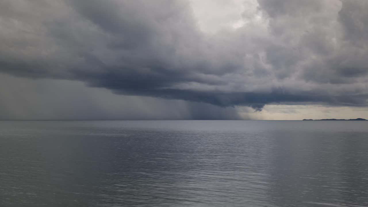 폭풍의 회색 구름이 물을 가로질러 달린다.