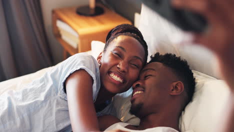 Selfie,-kiss-and-African-couple-on-bed-together