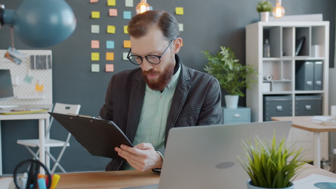 Businessman working on clipboard in modern office