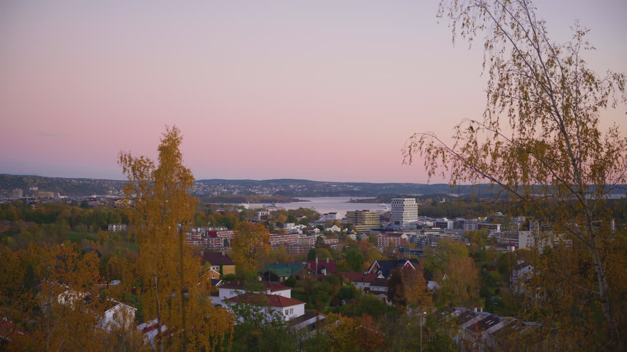 Laaja kuvakulma auringonlaskusta puistossa Oslossa, näkymä kaupunkiin kirkkaan taivaan alla