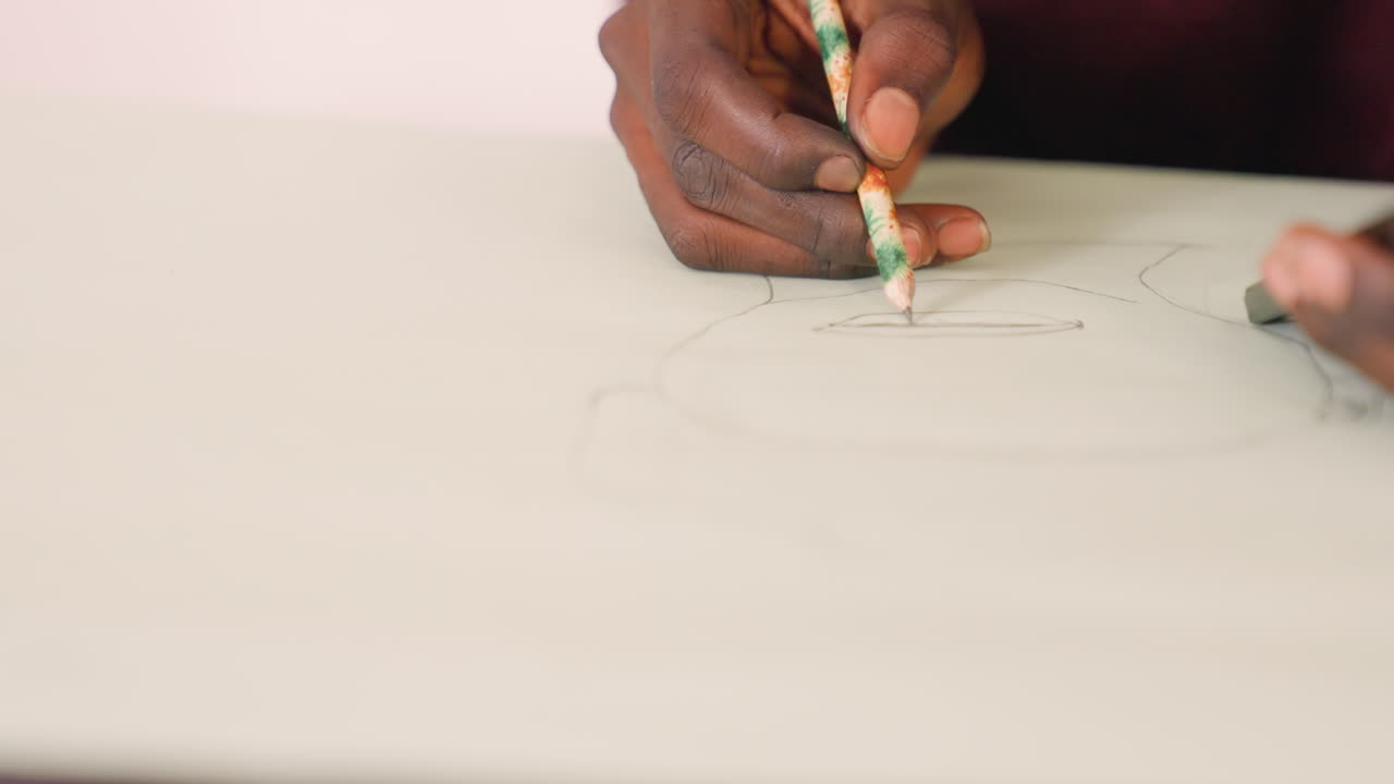 Closeup black artist sketching on paper, focused hands drawing circular outline with pencil and eraser, soft studio light, meditative precision, portrait study, illustrator at work, student practice
