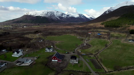 aerial ascending shot over a norwegian village with scenic mountains during day, northern scandinavia