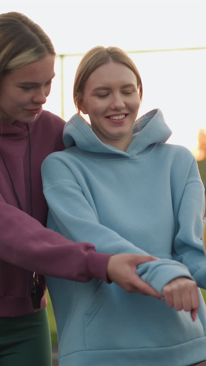 entrenador enseñando a los principiantes de voleibol cómo servir con una cálida sonrisa en su rostro, ambos de pie en la cancha al aire libre con la pelota de voleabol en la mano, mostrando energía positiva y deportividad