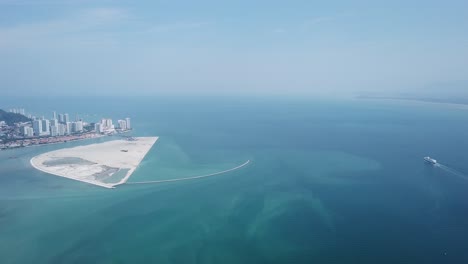 Aerial-view-a-cruise-ship-is-move-at-Penang-sea-near-reclamation-island